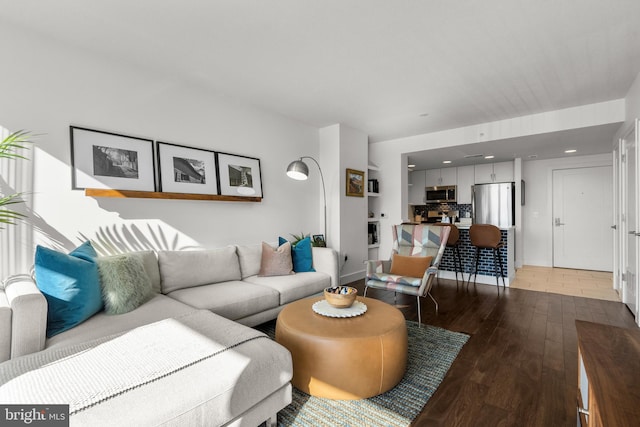 living area featuring baseboards, wood finished floors, and recessed lighting