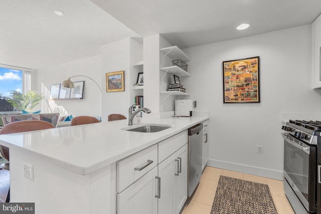 kitchen with light tile patterned floors, stainless steel appliances, open shelves, light countertops, and a sink