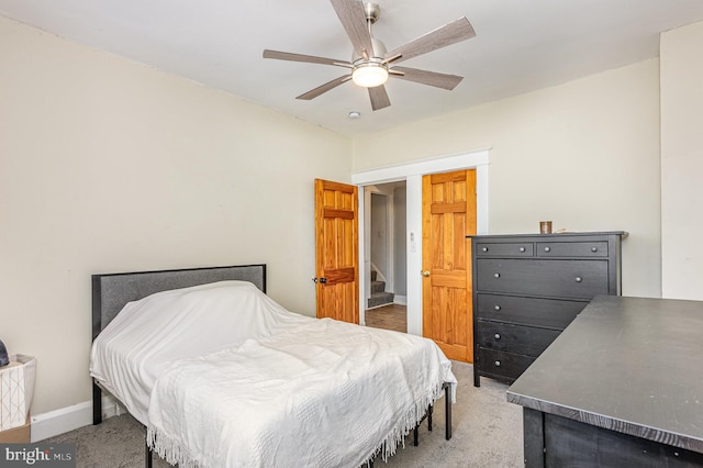 bedroom featuring a ceiling fan, light carpet, and baseboards