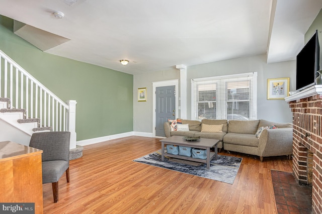 living room with baseboards, stairway, and wood finished floors
