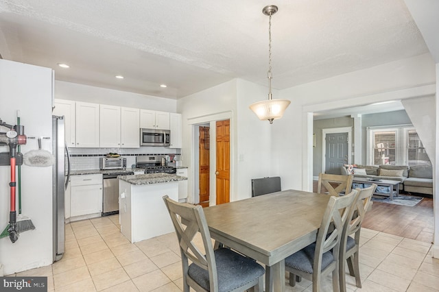 dining space with recessed lighting, a toaster, and light tile patterned floors