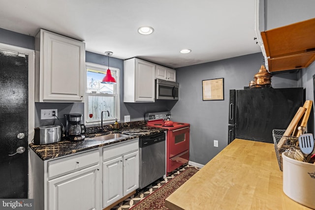 kitchen with appliances with stainless steel finishes, decorative light fixtures, sink, and white cabinets