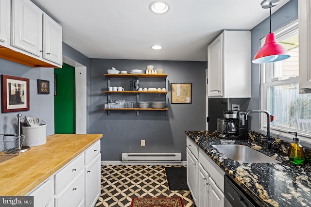 kitchen with hanging light fixtures, white cabinetry, sink, and butcher block countertops