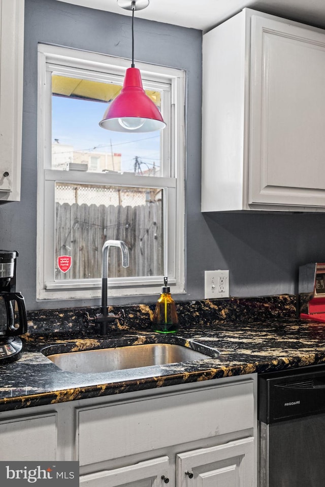 kitchen featuring white cabinetry, sink, dishwasher, and pendant lighting