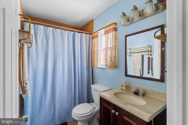 bathroom featuring vanity, curtained shower, and toilet