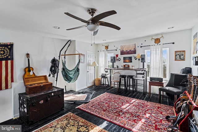 living room with dark hardwood / wood-style flooring and ceiling fan