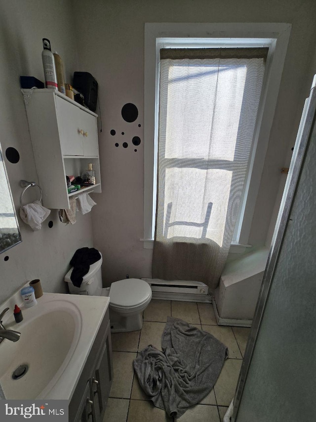 bathroom featuring tile patterned floors, a baseboard radiator, a healthy amount of sunlight, and vanity