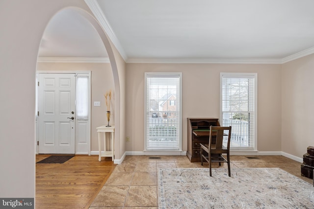 entryway featuring ornamental molding and plenty of natural light