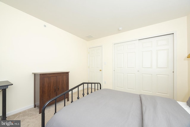 bedroom featuring light colored carpet and a closet