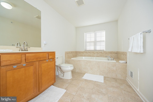 bathroom featuring tile patterned flooring, vanity, tiled bath, and toilet