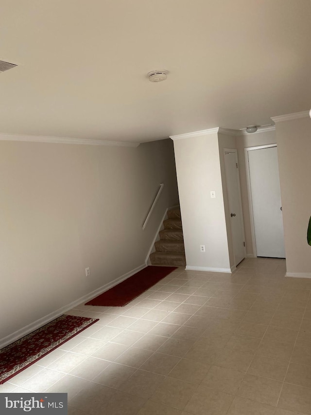 tiled spare room featuring crown molding