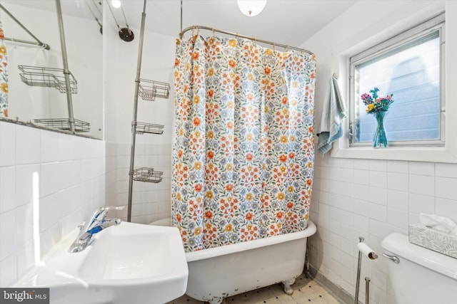 bathroom featuring sink, tile walls, and toilet