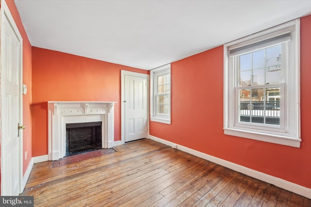 unfurnished living room with hardwood / wood-style flooring and a wealth of natural light