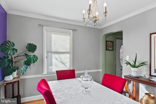 dining area featuring crown molding, a healthy amount of sunlight, and a chandelier