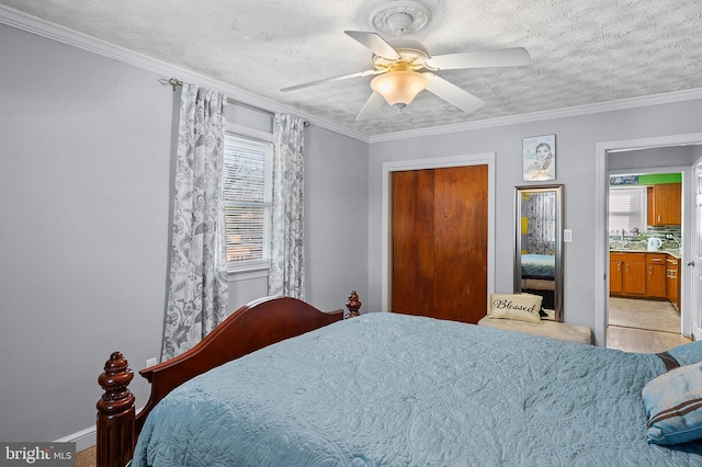 bedroom featuring ornamental molding, a textured ceiling, ceiling fan, and a closet