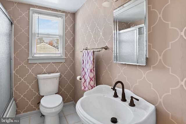 bathroom featuring toilet, tile patterned floors, and walk in shower