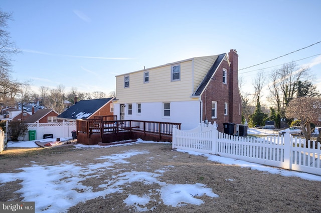 snow covered back of property featuring a wooden deck and cooling unit