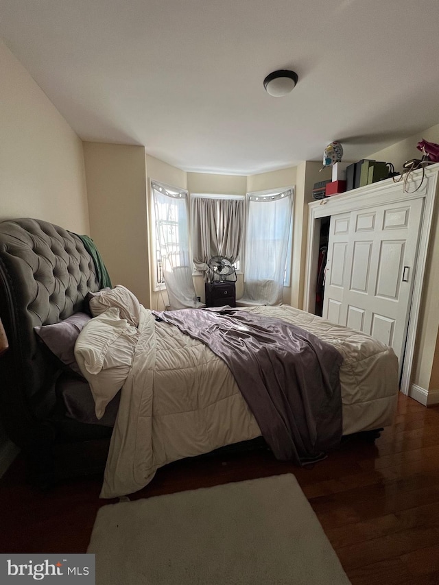 bedroom with dark hardwood / wood-style flooring