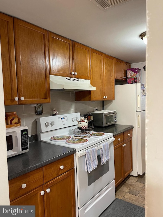 kitchen featuring white appliances and tasteful backsplash