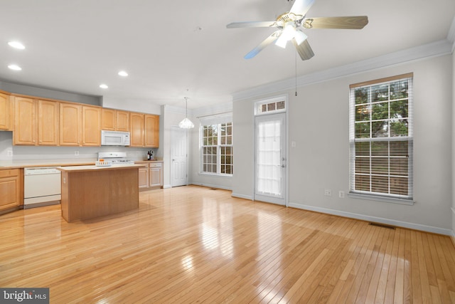 kitchen featuring light wood finished floors, light countertops, white appliances, and a kitchen island