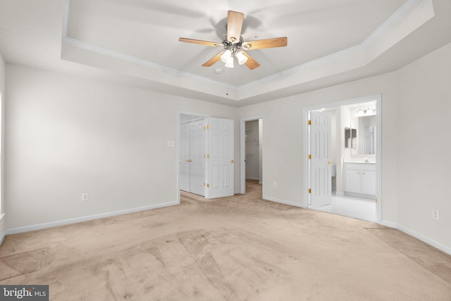 unfurnished bedroom featuring baseboards, ornamental molding, and a raised ceiling