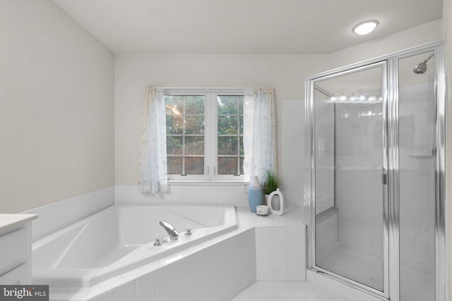 full bathroom with a garden tub, vanity, and a shower stall