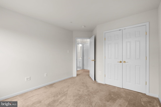 unfurnished bedroom featuring a closet, baseboards, and carpet flooring