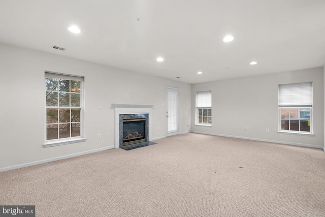 unfurnished living room with carpet flooring, visible vents, and baseboards