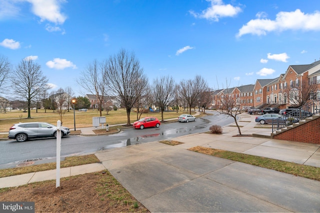 view of street with street lighting, a residential view, curbs, and sidewalks