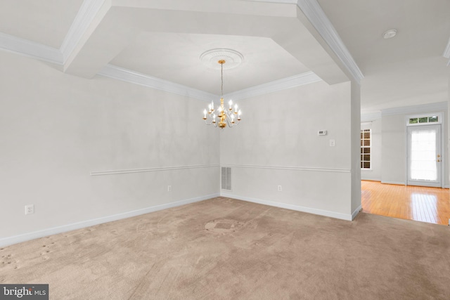 carpeted spare room featuring baseboards, an inviting chandelier, visible vents, and crown molding