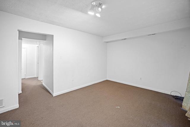 carpeted spare room with a textured ceiling