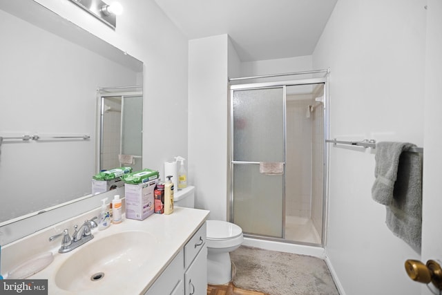 bathroom featuring vanity, toilet, and an enclosed shower