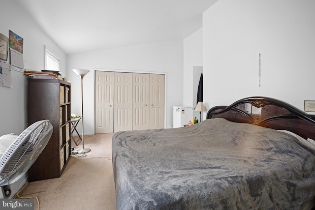 bedroom with lofted ceiling, light colored carpet, and a closet