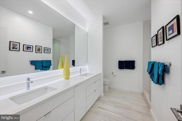 bathroom with vanity, toilet, and a shower