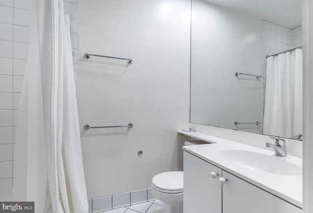 bathroom featuring toilet, curtained shower, tile patterned flooring, and vanity