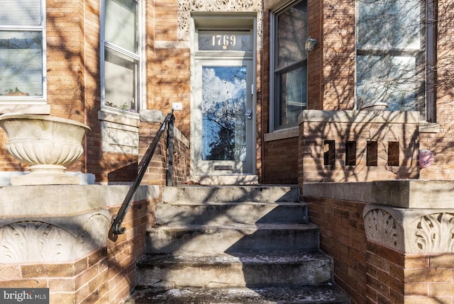 entrance to property featuring brick siding