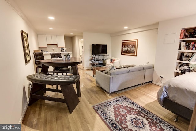 living area with light wood-type flooring, baseboards, and recessed lighting