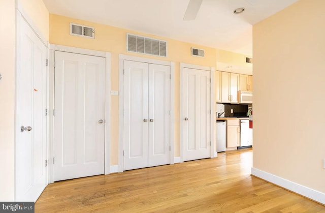 unfurnished bedroom featuring baseboards, visible vents, and light wood-style floors