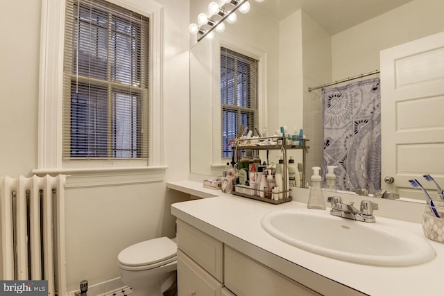 bathroom featuring toilet, curtained shower, radiator heating unit, and vanity