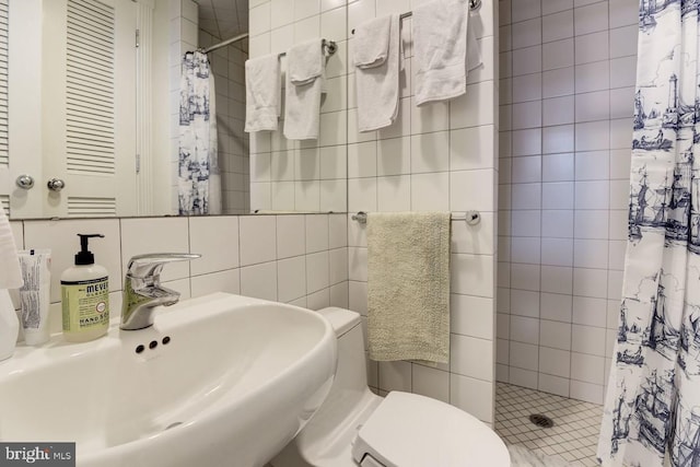 full bathroom with toilet, a shower stall, tile walls, and a sink