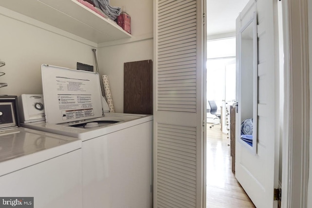 laundry room featuring light wood-type flooring, laundry area, and independent washer and dryer