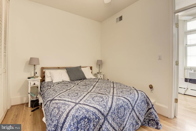 bedroom featuring light wood-style floors, baseboards, and visible vents