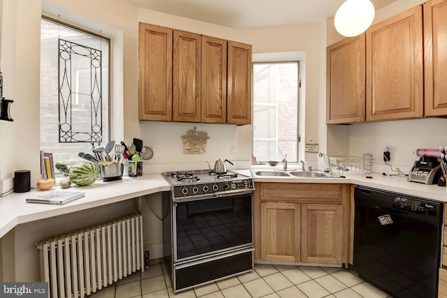 kitchen with a sink, light countertops, radiator, black appliances, and brown cabinetry