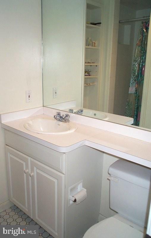 full bathroom featuring toilet, vanity, and a shower with shower curtain