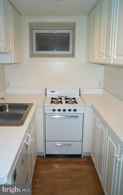 kitchen featuring a sink, white cabinetry, light countertops, and gas range gas stove