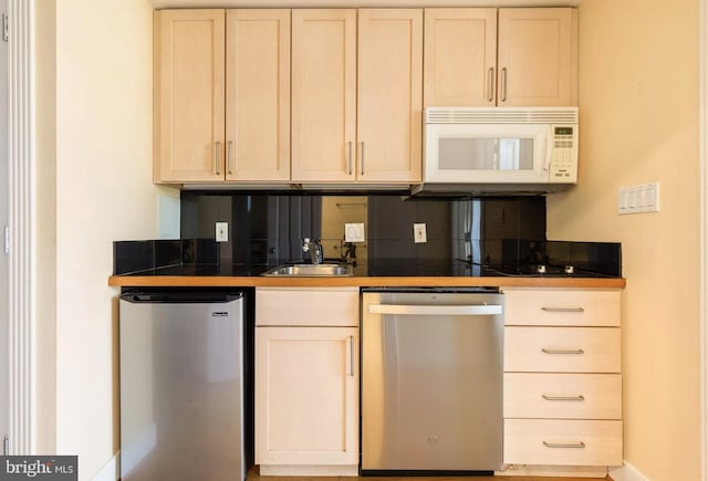 kitchen featuring tasteful backsplash, baseboards, tile countertops, appliances with stainless steel finishes, and a sink