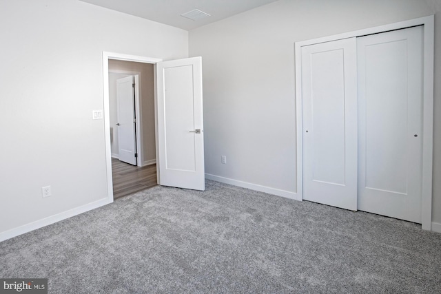 unfurnished bedroom featuring light colored carpet and a closet