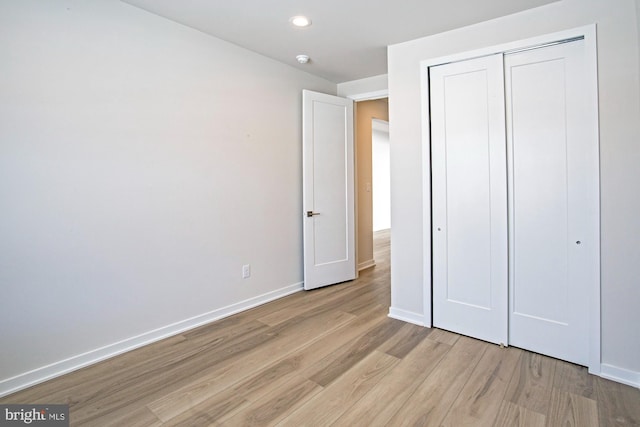 unfurnished bedroom featuring light hardwood / wood-style floors and a closet