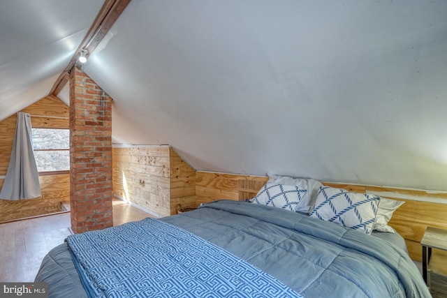 bedroom with wooden walls, wood-type flooring, and vaulted ceiling