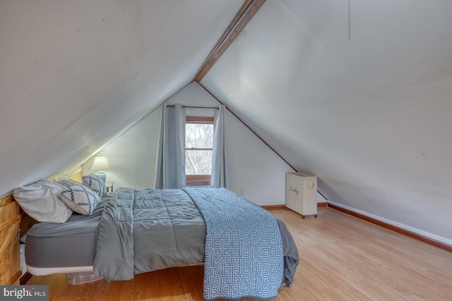 bedroom featuring lofted ceiling and light hardwood / wood-style flooring